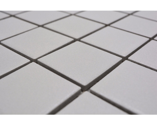 Detailní záběr na čtvercové, světlé keramické mozaikové dlaždice