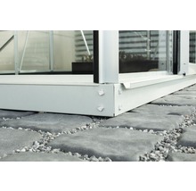 Detail kovového základu skleníku na kamenné podlaze
