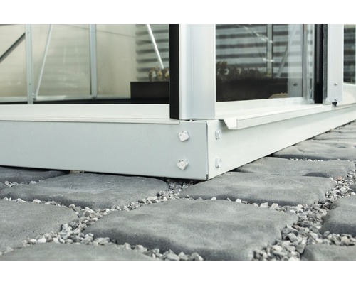 Detail kovového základu skleníku na kamenné podlaze