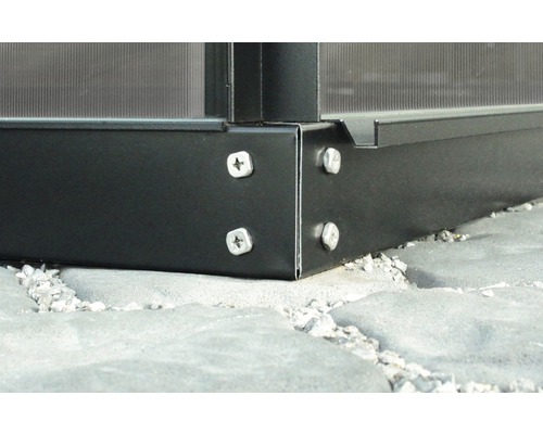 Detailní pohled na černý zahradní domek se stříbrnými šrouby na šedé kamenné podlaze
