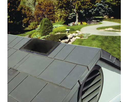 Střecha domu se střešním oknem a větrací mřížkou