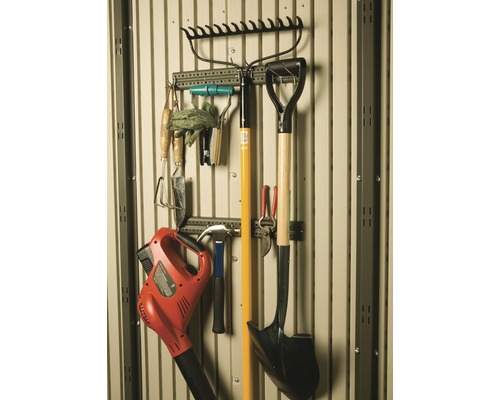 Zahradní nářadí, jako jsou hrábě, lopata, foukač listí a kladivo, na nástěnném držáku.