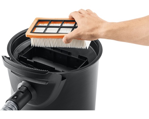 Muž vkládá filtr do vysavače.