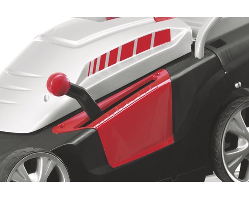 Detailní pohled na sekačku na trávu s červenou pákou pro nastavení výšky sečení