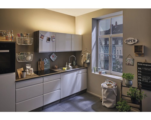 Světlá kuchyně s moderními skříňkami, dřezem a dekorací