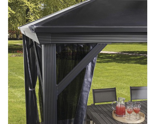 Detailní pohled na zahradní altán se závěsy a zahradním nábytkem