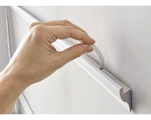 Upevnění ozdobné lišty lepicí páskou na zeď