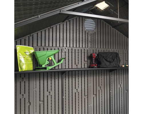 Pohled do interiéru zahradního domku s policemi a zahradním náčiním