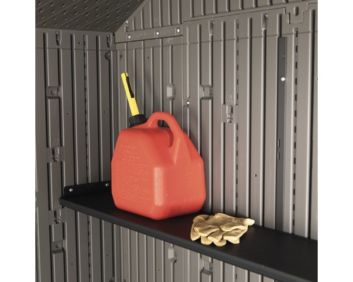 Vnitřní pohled na zahradní domek s policí, kanystrem na benzín a pracovními rukavicemi