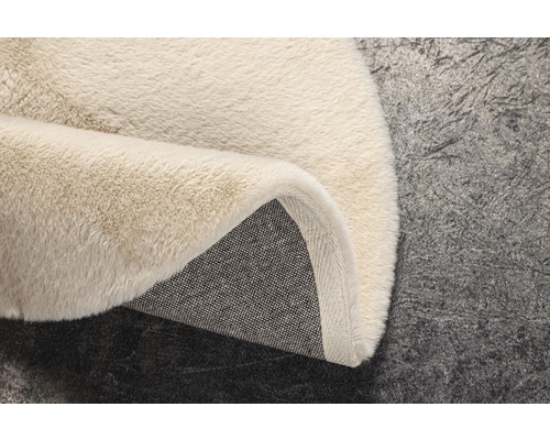 Detail béžového koberce s vysokým vlasem a textilní zadní stranou