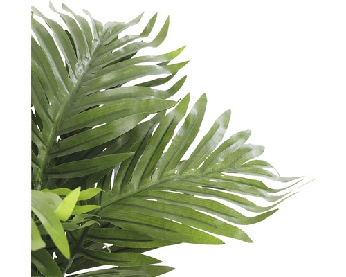 Detail umělé palmy se zelenými listy jako dekorace