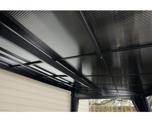 Detailní záběr střechy altánu s kovovou konstrukcí a vlnitým povrchem.