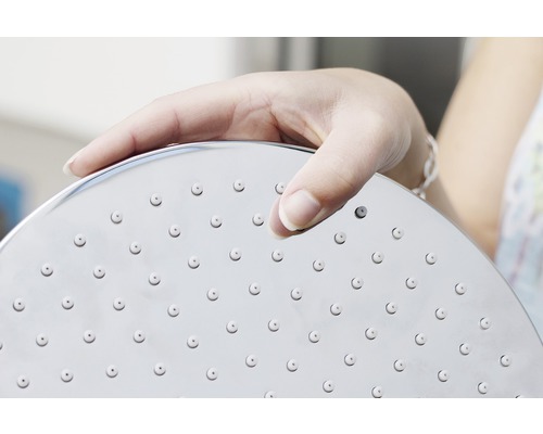 Ruka drží sprchovou hlavici s hlavicí