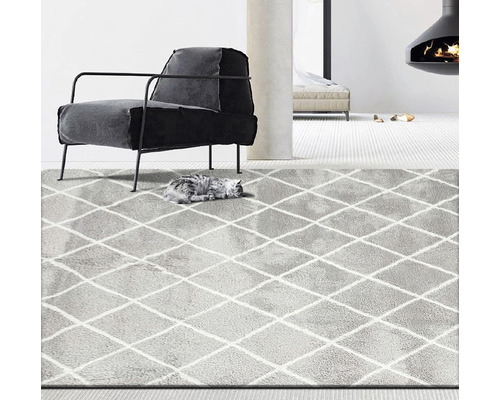 Šedý koberec s kosočtvercovým vzorem v obývacím pokoji s křeslem a krbem.