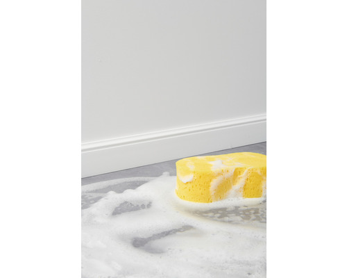 Žlutá čisticí houba s pěnou na podlaze