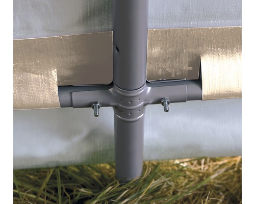 Detailní pohled na rám párty stanu se šrouby a trávou ve spodní části obrázku