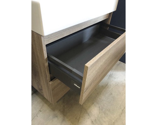 Skříňka pod umyvadlo s otevřenou zásuvkou a logem Blum