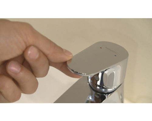 Ruka ovládá vodovodní baterii Hansgrohe v koupelně