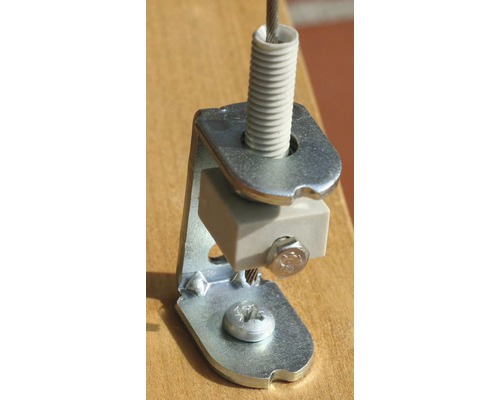 Detailní záběr držáku ocelového lanka se šrouby a pružinovým prvkem pro upevnění.