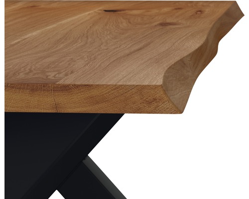 Detailní pohled na dubovou desku stolu s okrajem stromu a černým podstavcem