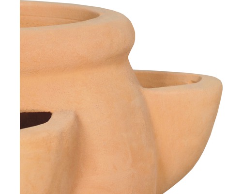 Detailní pohled na terakotovou vázu na rostliny s několika otvory pro rostliny.