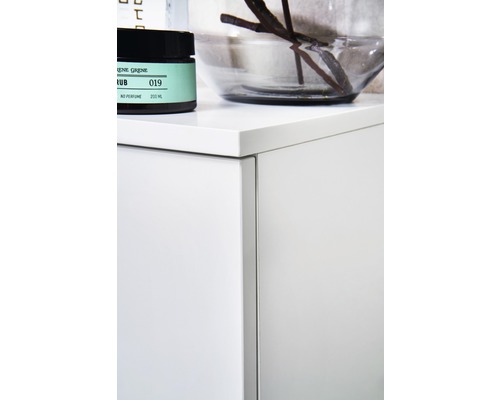 Detailní pohled na koupelnovou skříňku s kosmetickými produkty a dekorací