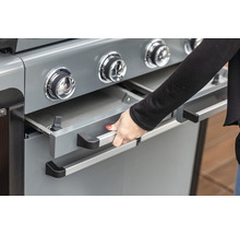 Detail plynového grilu s otevřenou zásuvkou, ovládaný rukou