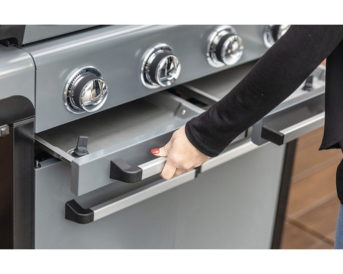 Detail plynového grilu s otevřenou zásuvkou, ovládaný rukou