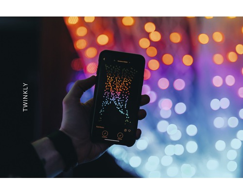 Ruka drží smartphone s aplikací Twinkly před světly