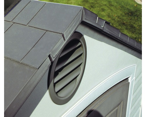Detailní pohled na střechu s taškami a kruhovou větrací mřížkou.