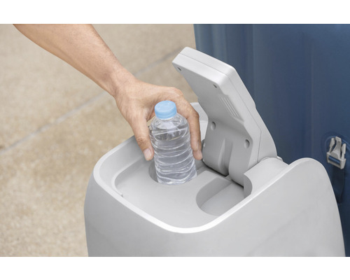 Osoba vkládá láhev s vodou do odpadkového koše.