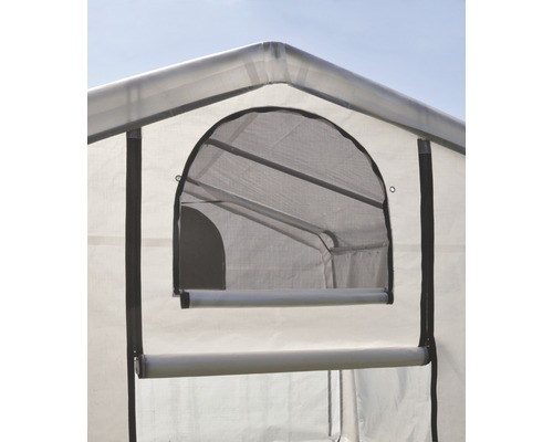 Detailní pohled na skleník s oknem a roletou pro větrání.