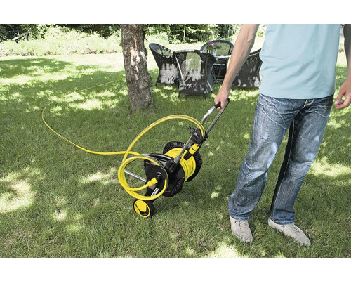 Zahradní scéna s žlutým navijákem hadice pro zavlažování zahrady