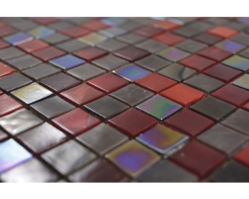 Detailní záběr čtvercových skleněných mozaikových dlaždic v červených a hnědých tónech.