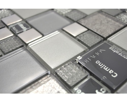 Detailní pohled na skleněné mozaikové dlaždice v různých odstínech šedé a texturách.