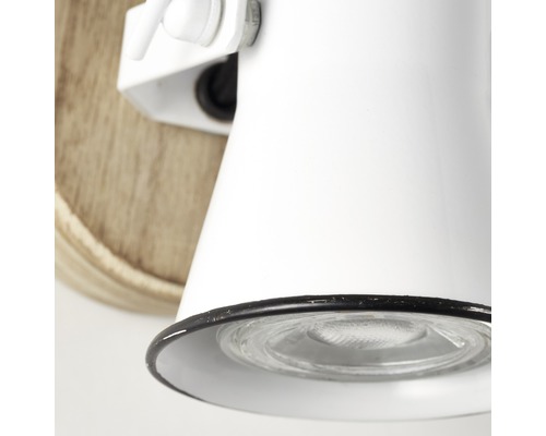 Detail bílého nástěnného svítidla s dřevěnou základnou