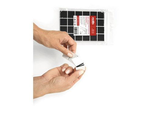 Čtvercové samolepicí podložky, 20 krát 20 milimetrů, v balení po 24 kusech. Osoba odstraňuje ochrannou fólii z podložky.