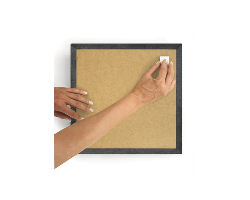 Osoba připevňuje lepicí pásku k rámu obrazu.