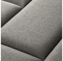 Detail šedého polštáře pohovky.