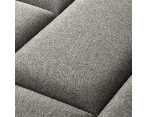 Detail šedého polštáře pohovky.