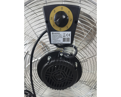 Detailní pohled na kovový podlahový ventilátor s regulátorem rychlosti a motorem