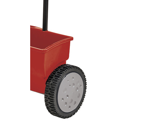 Detailní pohled na posypový vozík s červenou nádobou a černou rukojetí