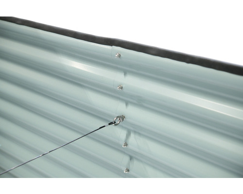 Detail kovové stěny zahradního domku se šrouby a okem