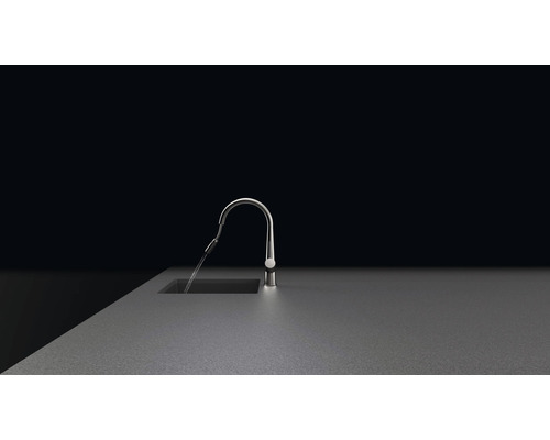 Vodovodní kohoutek na pracovní desce s tekoucí vodou