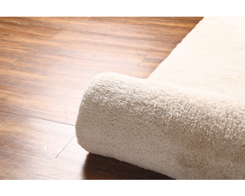 Detailní pohled na srolovaný koberec na dřevěné podlaze