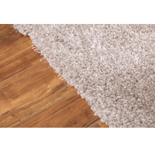 Detailní pohled na chlupatý koberec na dřevěné podlaze