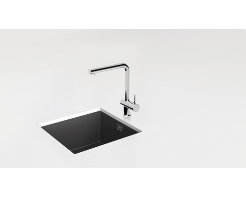 Umyvadlová baterie a dřez ve světlém kuchyňském prostředí.