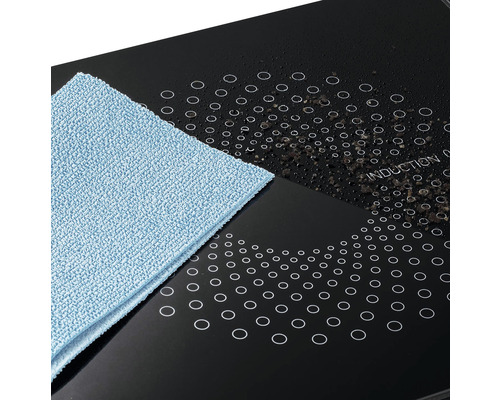 Sklokeramická indukční varná deska s čisticím hadříkem a nečistotami