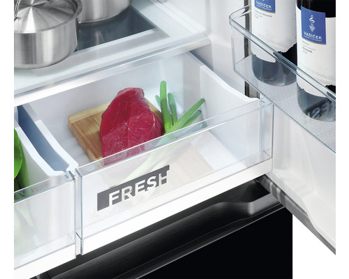 Detailní záběr chladničky s přihrádkou na čerstvé potraviny obsahující maso a zeleninu