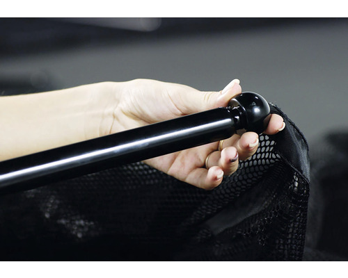 Ruka drží černý bazénový skimmer s rukojetí